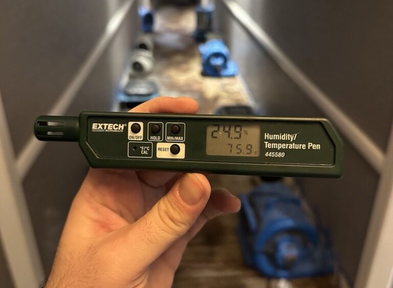 Novaco Restoration technician using Extech humidity/temperature pen to monitor drying during water damage restoration in a Vancouver BC hallway