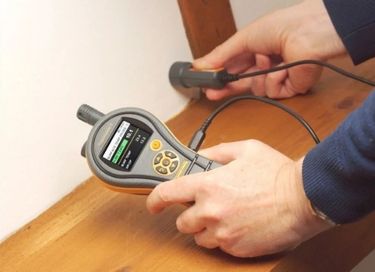 Digital hygrometer measuring indoor humidity during mold inspection